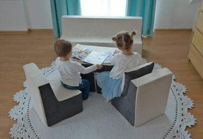 Dreng og pige sidder og læser bøger, imens de sidder på børnestolene i skum
