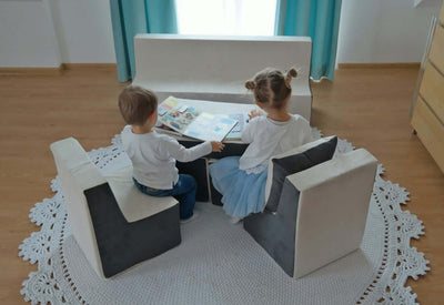 en dreng og en pige sidder og læser bøger i skumlegetøjssættet