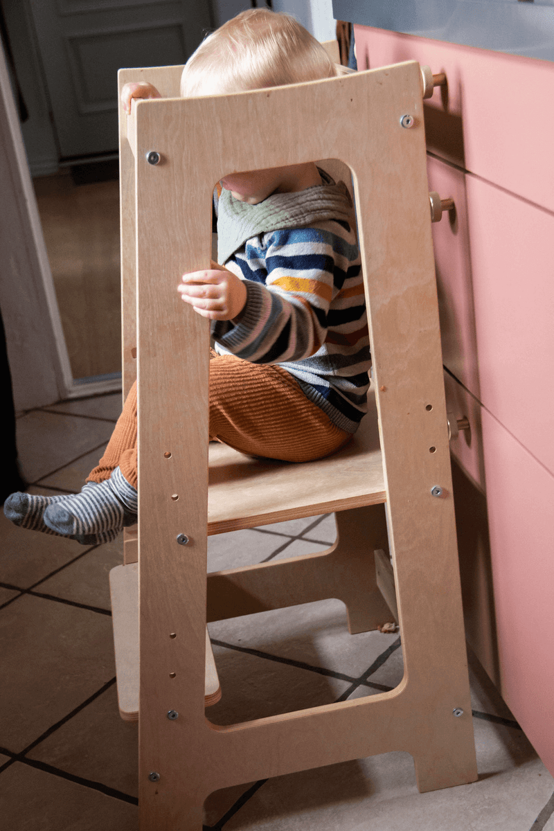 Lille dreng sidder og leger i sit læringstårn 